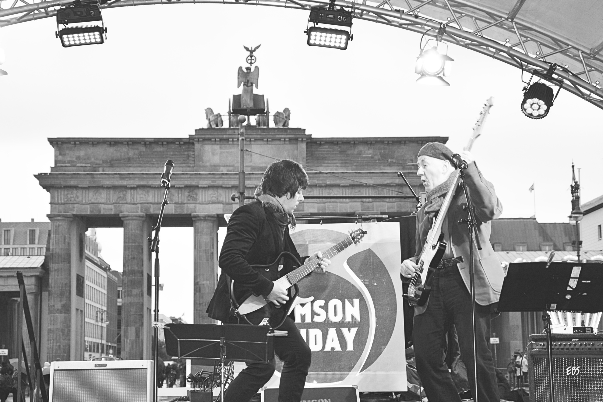 Leon and Thommi of the band Crimson Sunday perform on stage with the Brandenburg Gate in the background during a music event.