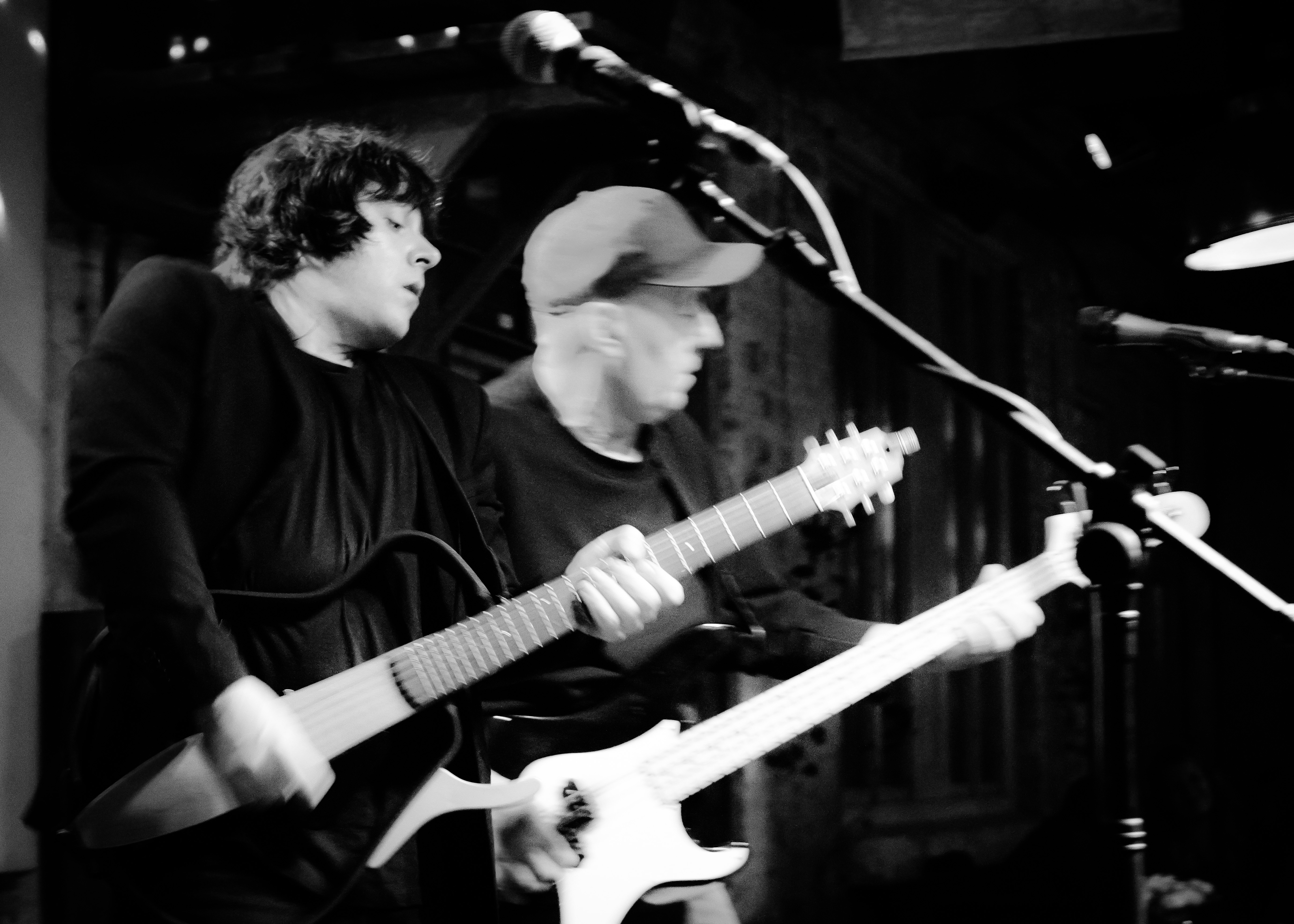 Two musicians Leon and Thommi performing live on stage with electric guitars, capturing the energy of a rock concert.